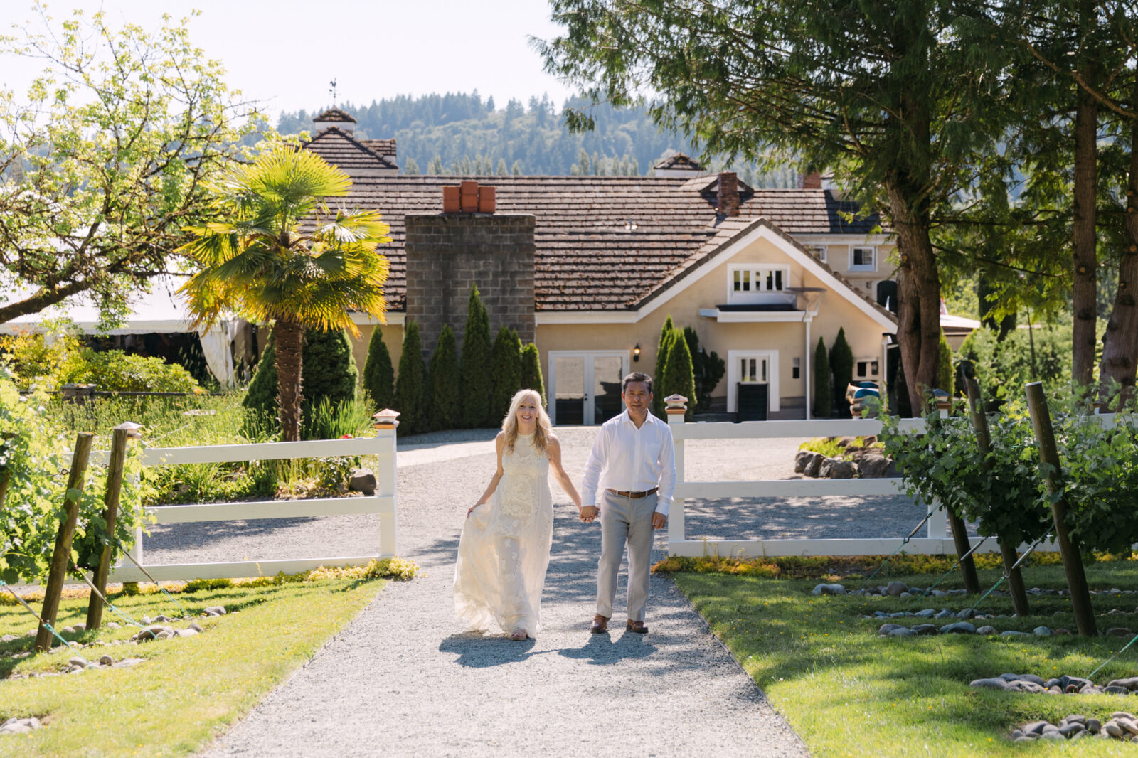 Bride and groom walking hand in hand on the Chateau Lill grounds.