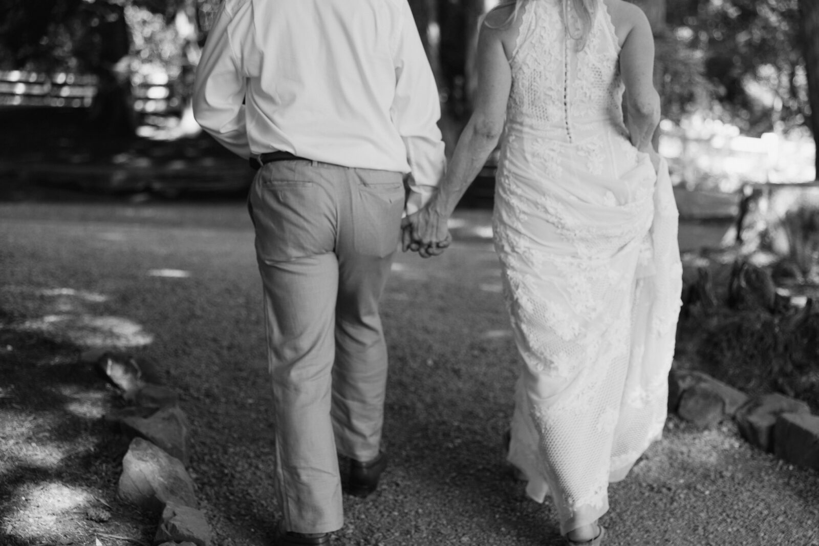 Bride and groom holding hands during black and white Chateau Lill wedding portraits.