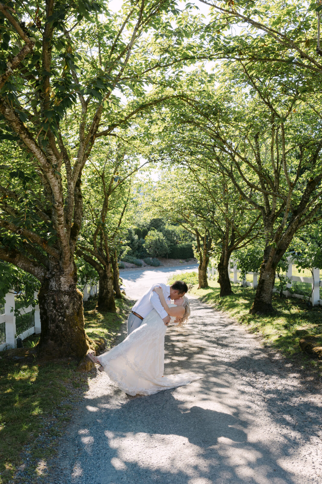 Groom dipping bride beneath the trees during Chateau Lill wedding portraits.