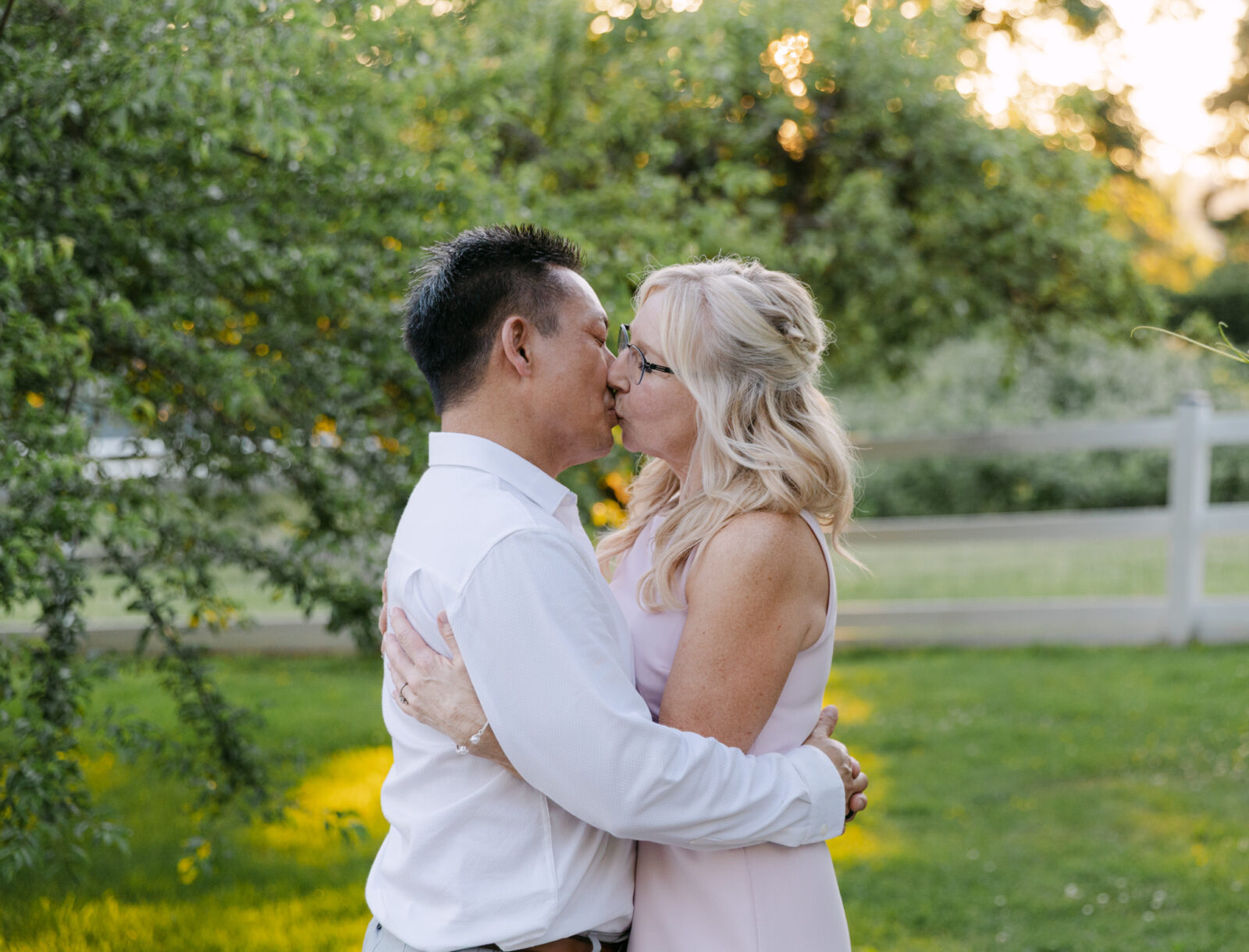 Bride and groom sharing a golden hour kiss after changing into reception attire.