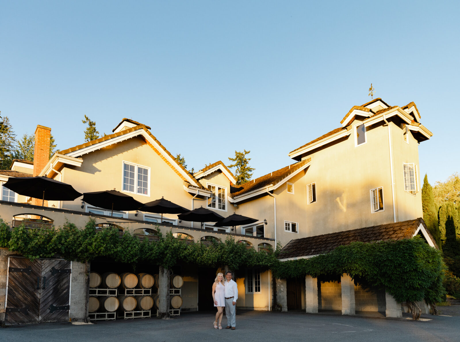 Bride and groom standing outside Chateau Lill during golden hour portraits.