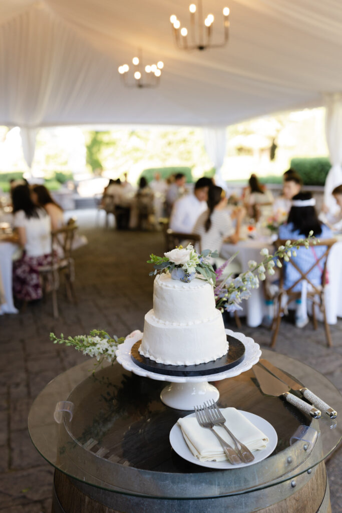 White wedding cake with floral details during a Chateau Lill wedding reception.