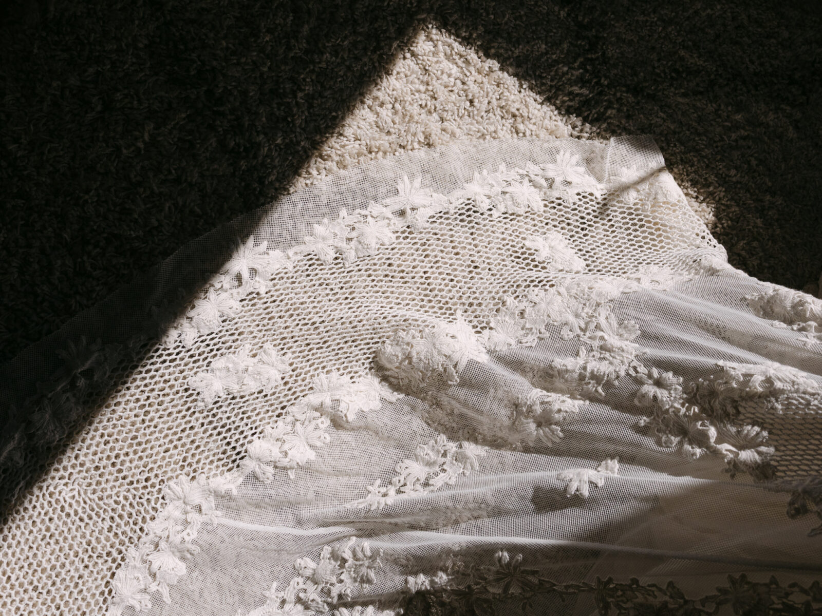 Close-up of the bride’s lace wedding dress with floral embroidery.