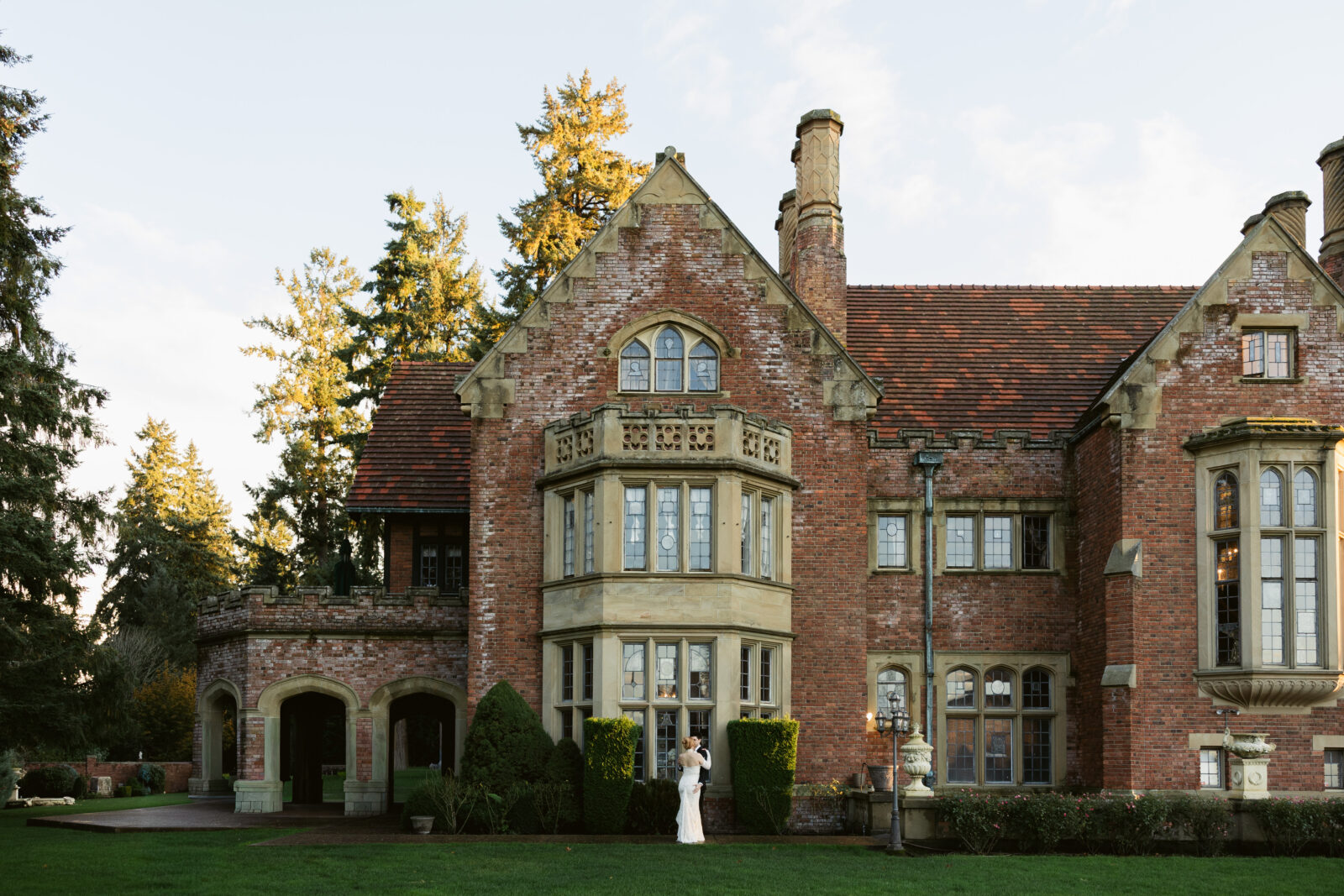 Bride and groom posing outside of Thornewood Castle, a historic Tacoma wedding venue.