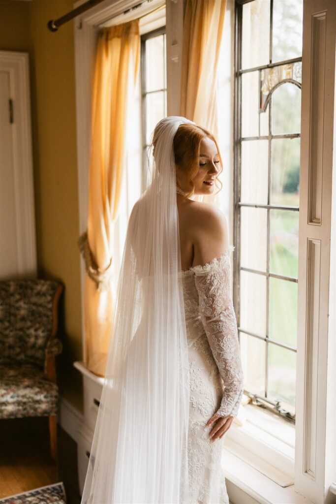 Bride posing by one of the indoor windows.
