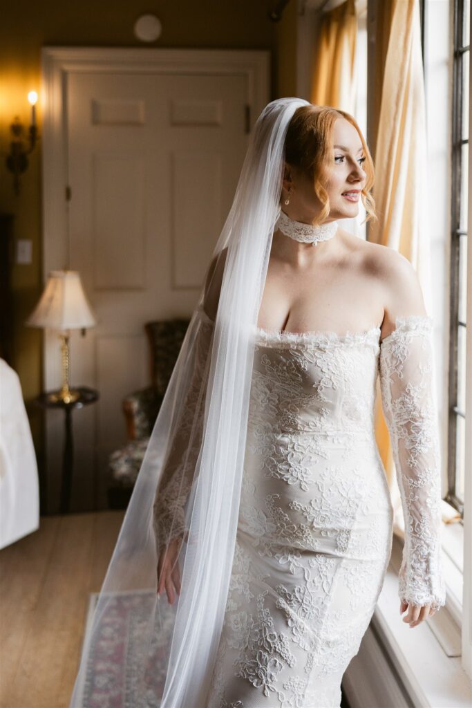 Bride posing by an indoor window in one of the suites.