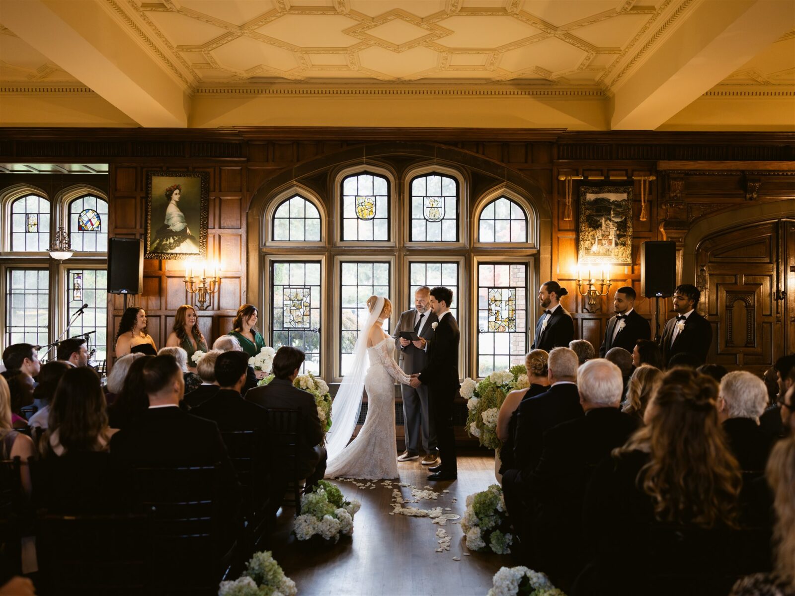Bride and groom holding hands at the altar during their Great Hall wedding ceremony at Thornewood Castle.