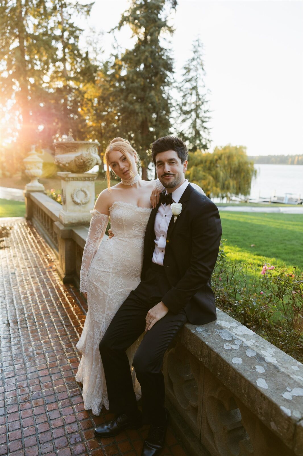 Bride and groom posing during golden hour in front of the lake at Thornewood Castle.