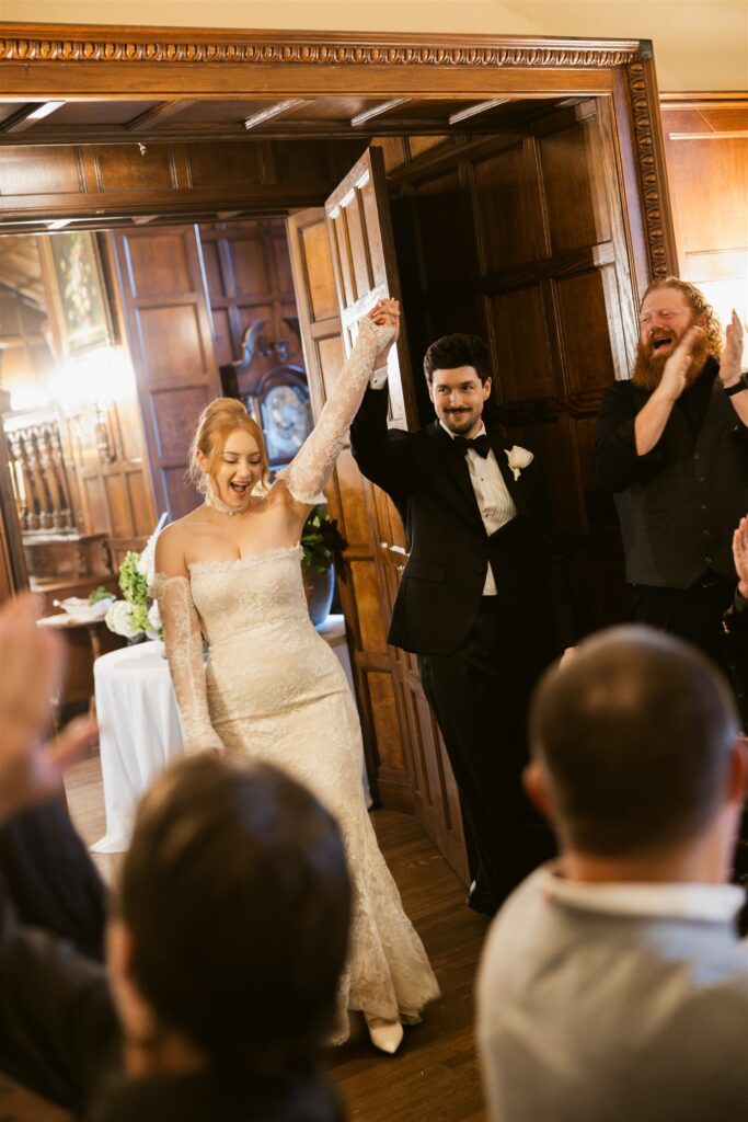 Bride and groom making their grand entrace in the Great Hall at Thornewood Castle wedding venue.