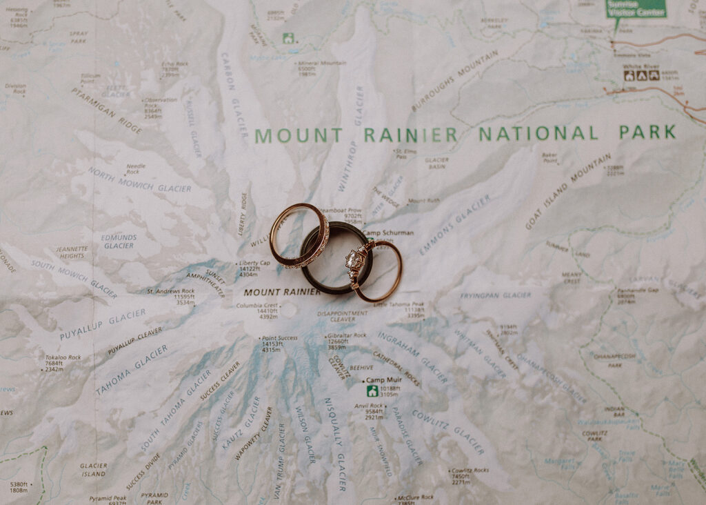 Elopement rings photographed on a Mount Rainier National Park map
