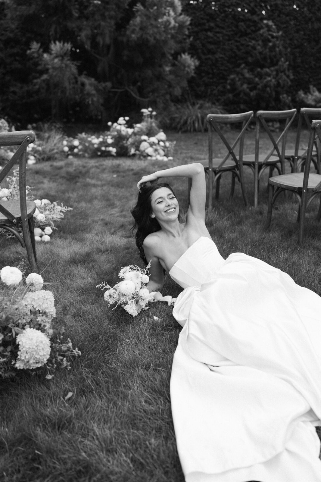 Black and white photo of bride laying in ceremony space at Briarwood Estate wedding.