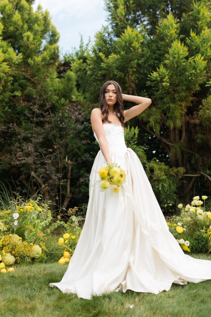 Bride in strapless wedding gown holding yellow bouquet at Briarwood Estate wedding ceremony.