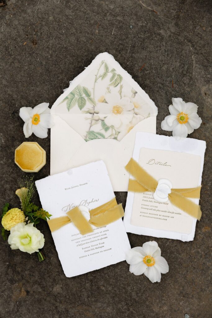 Wedding invitation suite with yellow ribbon and floral details at Briarwood Estate wedding in Washington.