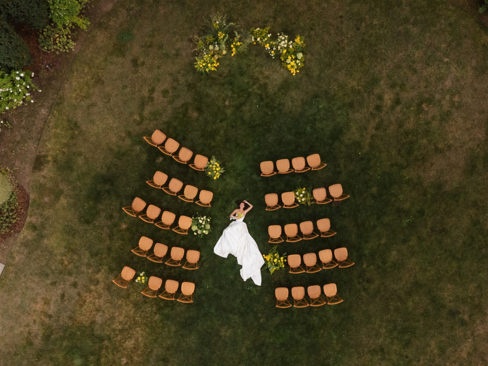 Aerial drone shot of Briarwood Estate wedding ceremony layout with bride lying in the aisle.