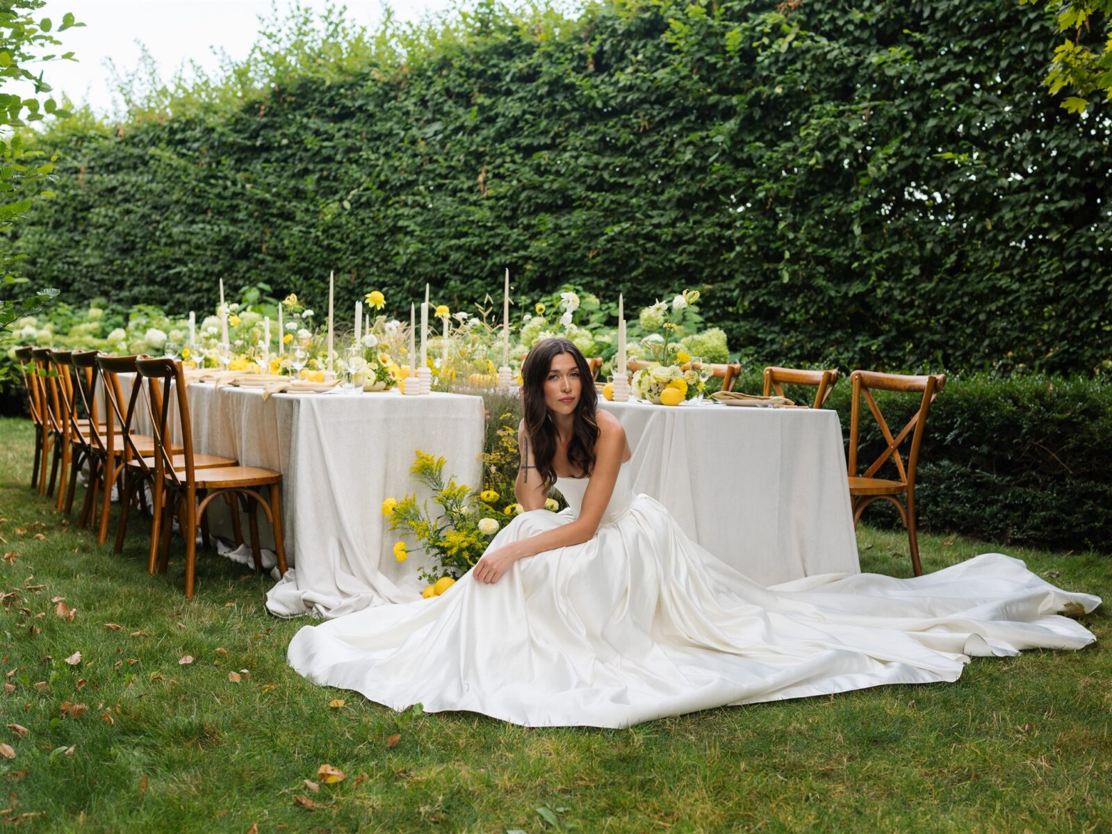 Bride posing in front of a styled wedding reception table at Briarwood Estate with yellow florals and decor.