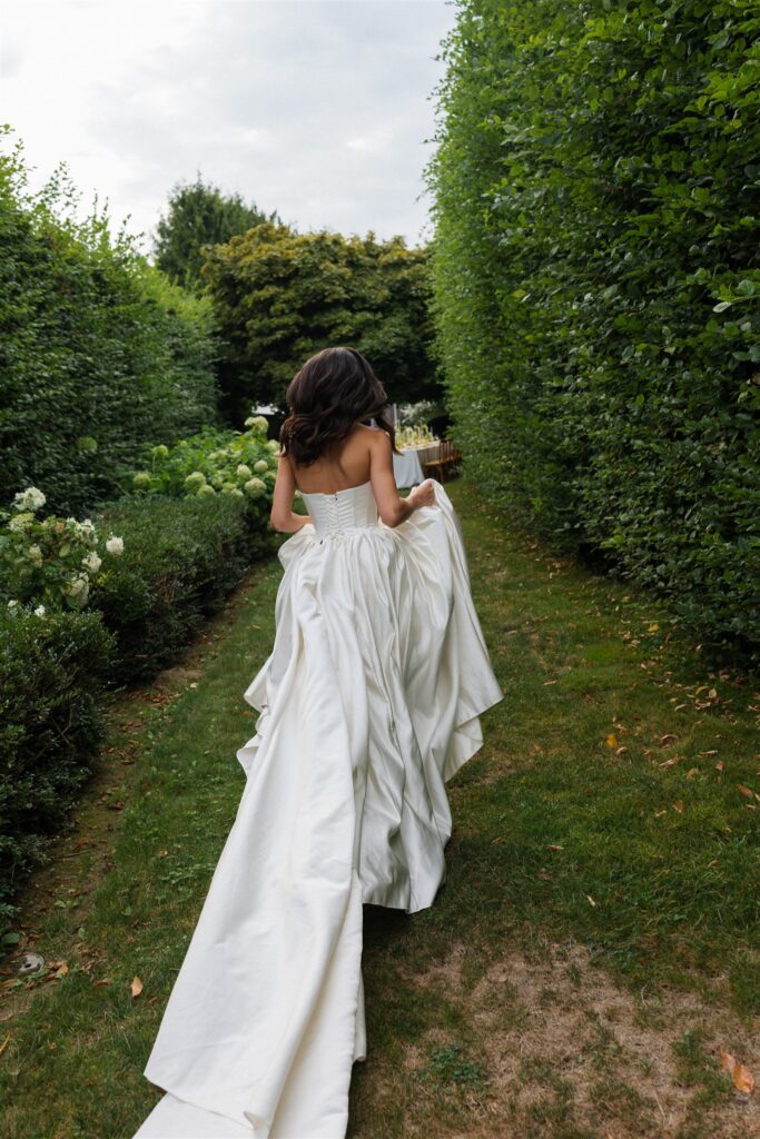 Bride walking through garden reception space at Briarwood Estate wedding.