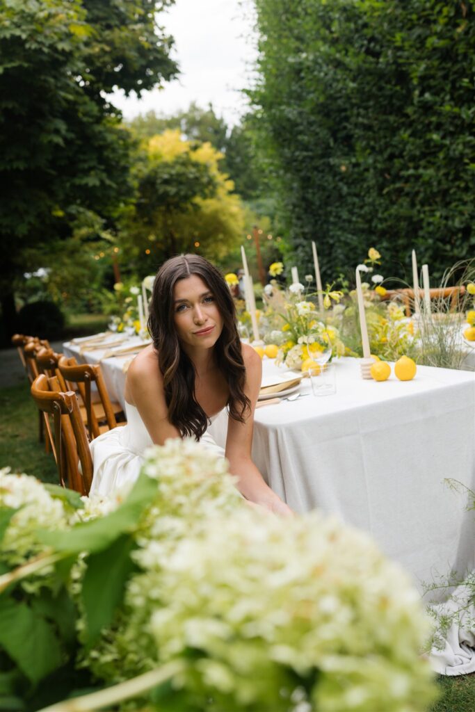 Close up portrait of a bride sitting at her styled wedding reception table.