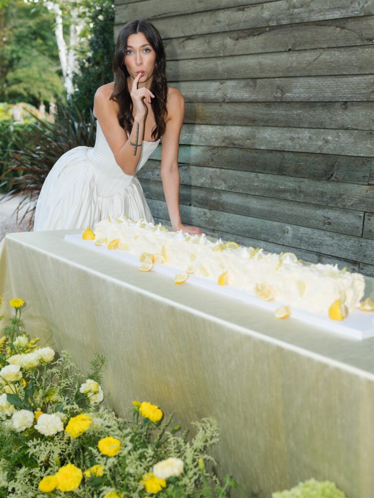 Playful portrait of a bride licking the ice cream off of her lemon cake from an editorial styled shoot.