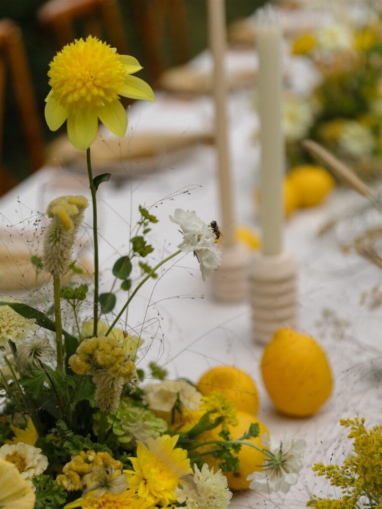 Reception table with candles, florals, and neutral linens.