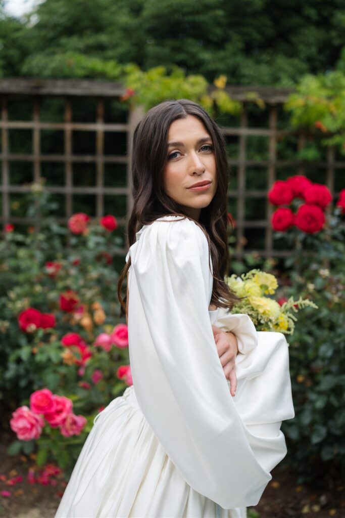 Close up bridal portrait with red roses in background at Briarwood Estate wedding rose garden.