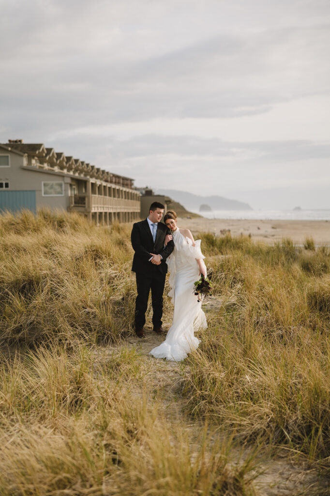 Bride and groom walking in the beach grass during their Cannon Beach elopement.