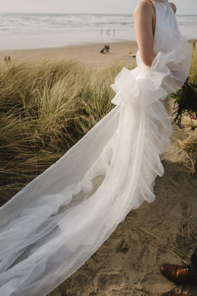 Close up shot of a bride walking along the dunes and beach grass at Cannon Beach.