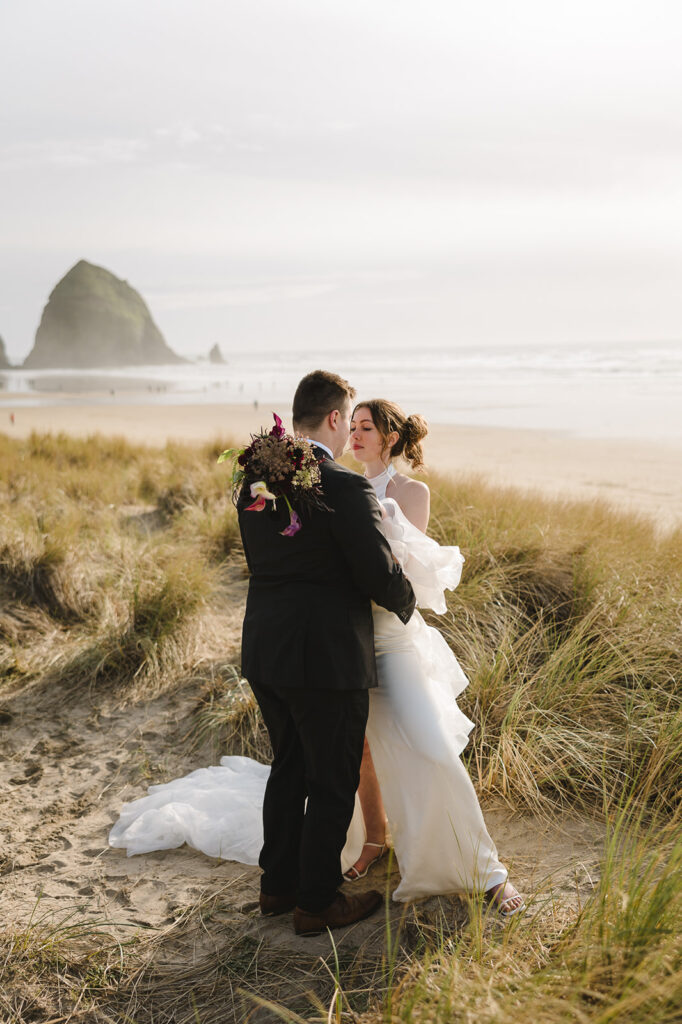 Bride and groom posing close together for their Cannon Beach elopement.