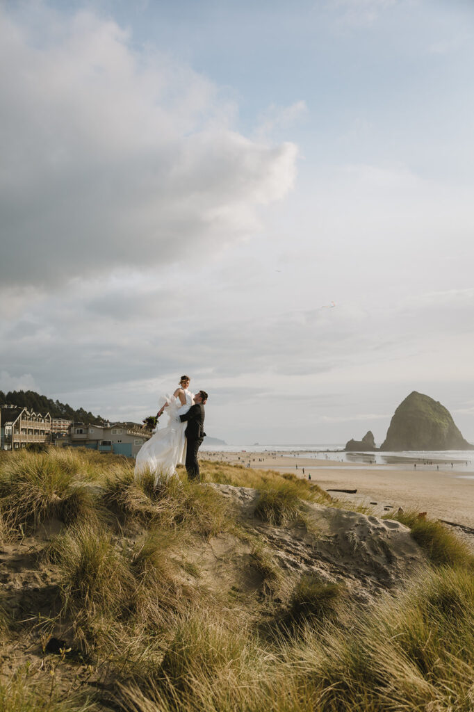 Groom lifting his bride in the air during their Cannon Beach elopement.