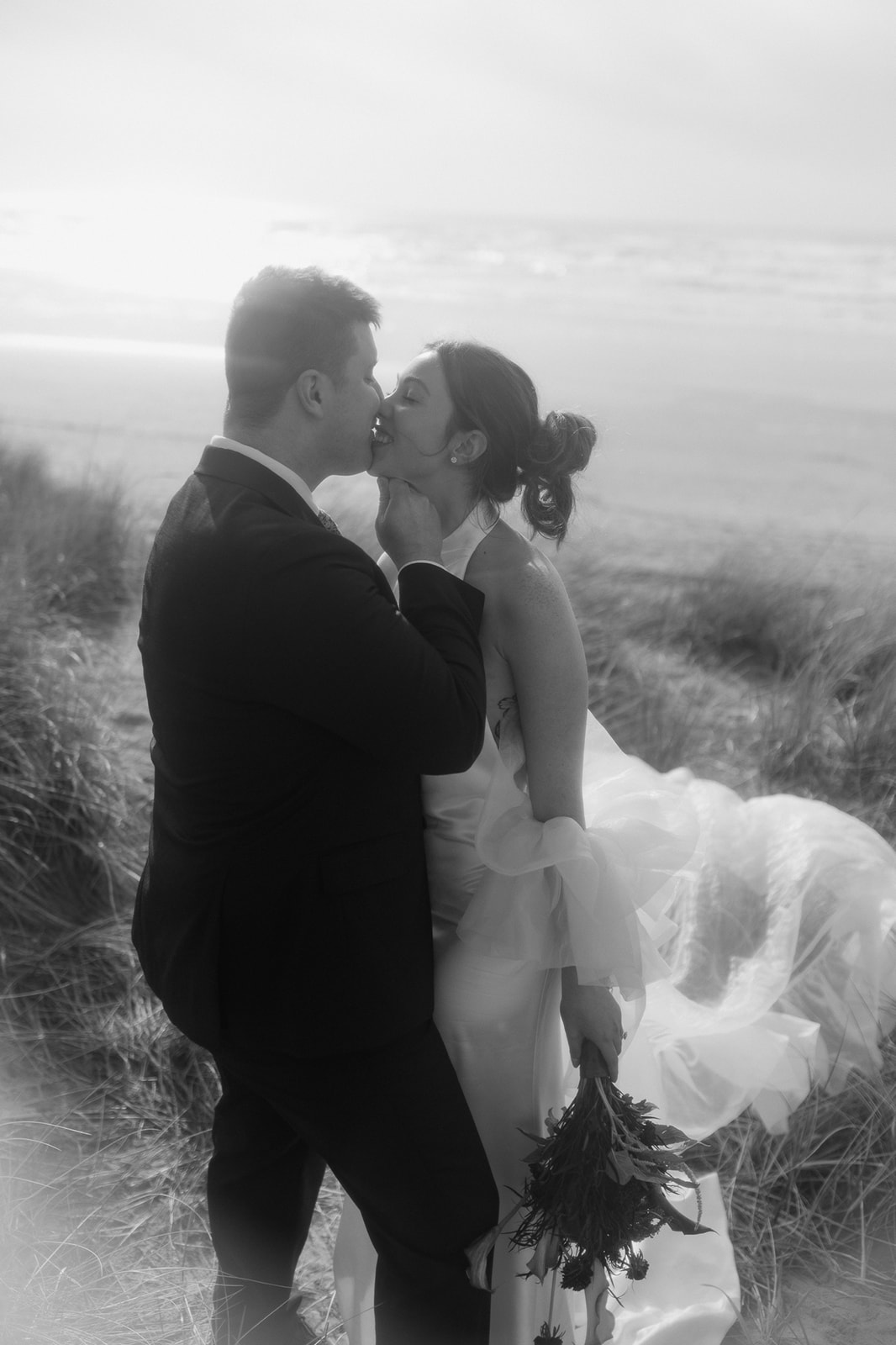 Black and white romantic elopement photo of a bride and groom going in for a kiss.