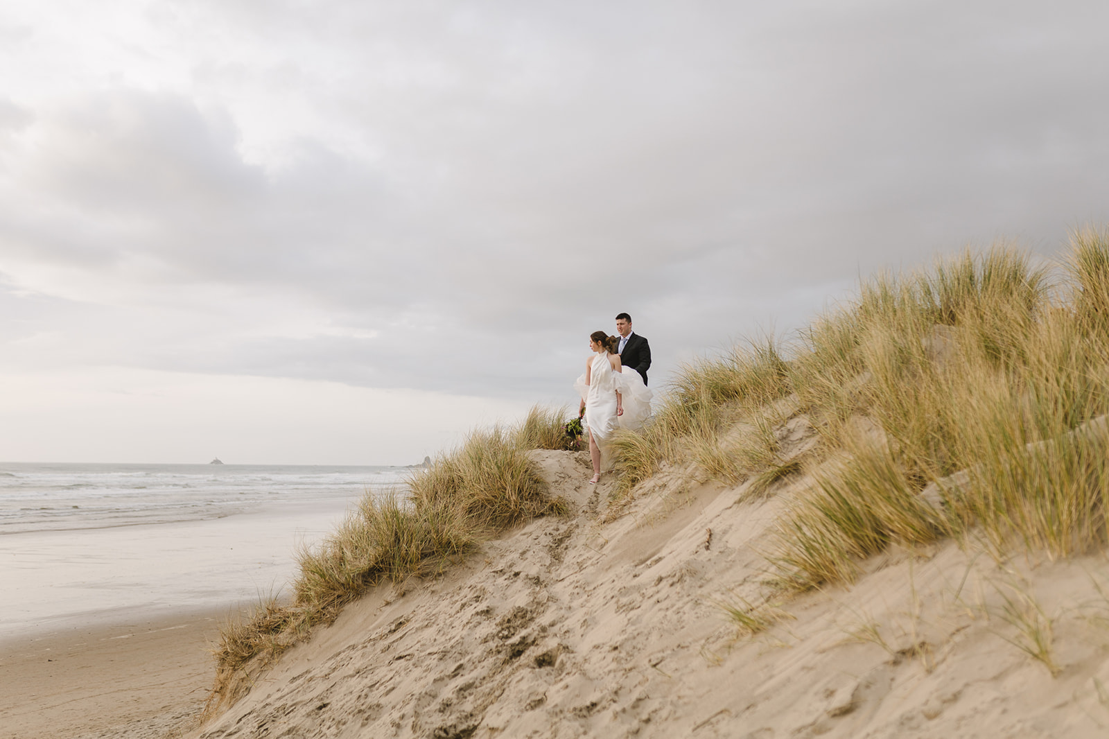 Bride and groom walking the sand dunes for their Cannon Beach elopement.