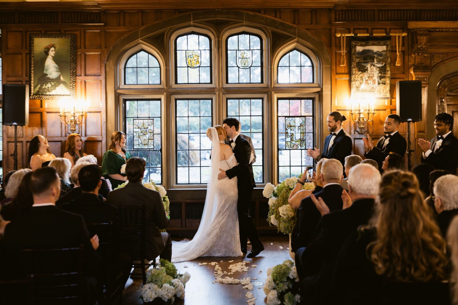 Bride and groom kissing during their indoor wedding ceremony in the Grand Hall at Thornewood Castle.