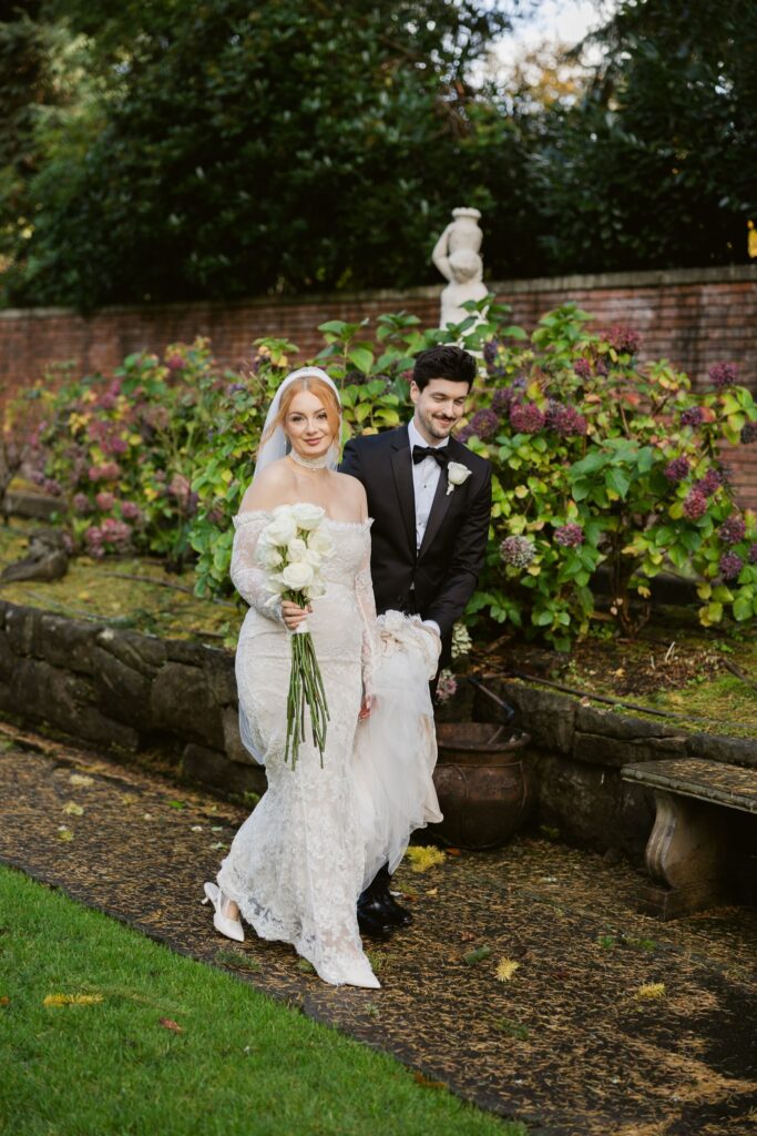 Bride and groom walking through the sunken secret garden at Thornewood Castle wedding venue in Lakewood, WA.