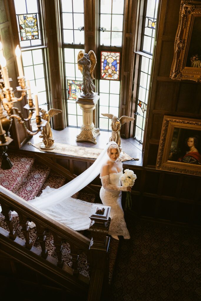 Indoor portrait of the bride walking down the historic staircase at Thornewood Castle wedding venue in Lakewood, WA.