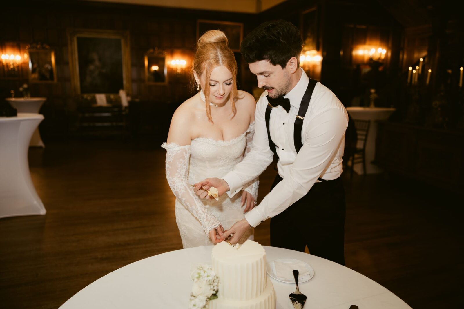 Bride and groom cutting into their wedding cake.