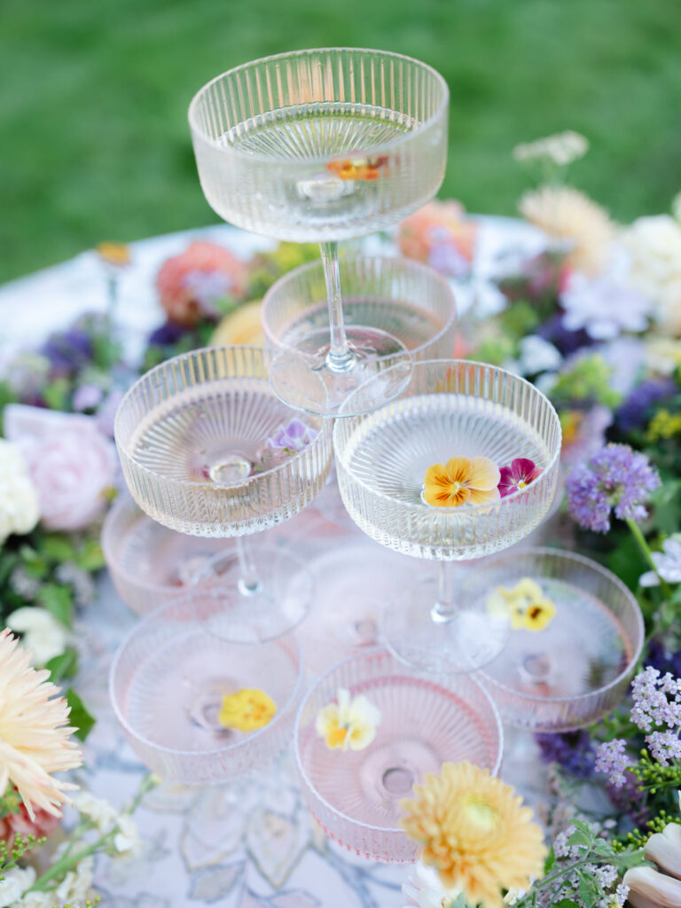 Close up shot of a colorful champagne tower with florals.