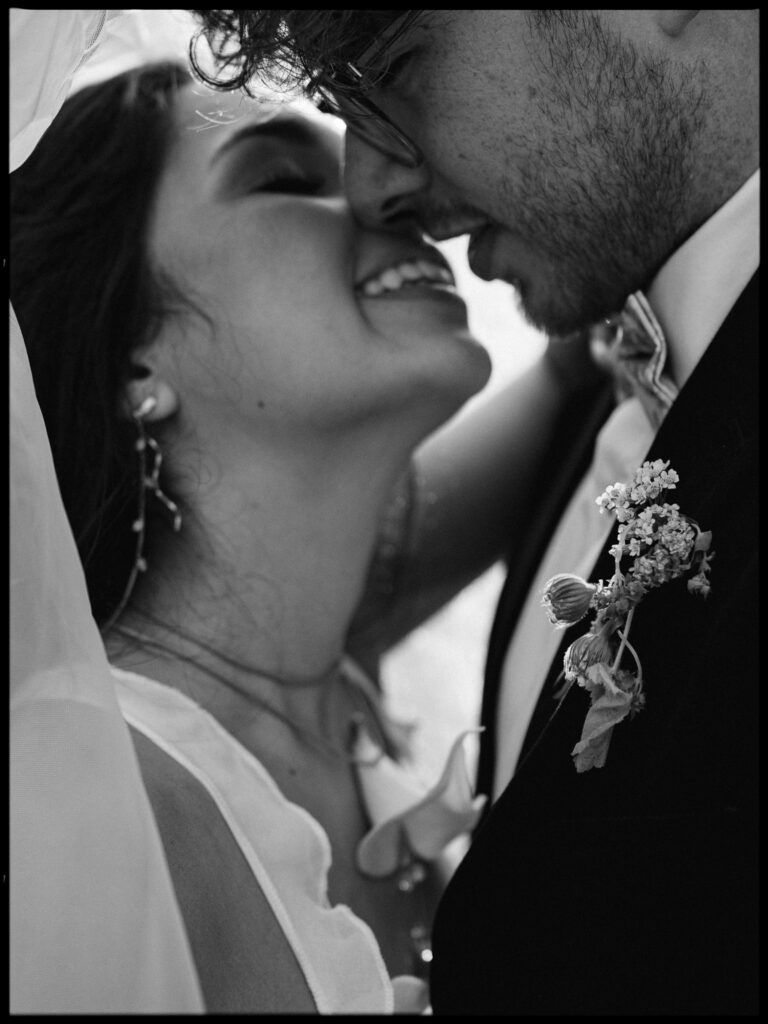 Black and white close up of couple smiling under a veil at Foxglove Lodge Vashon Island.