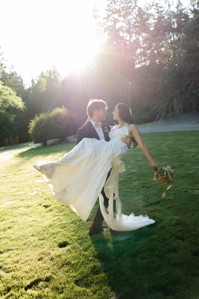 Groom carrying his bride during golden hour portraits.