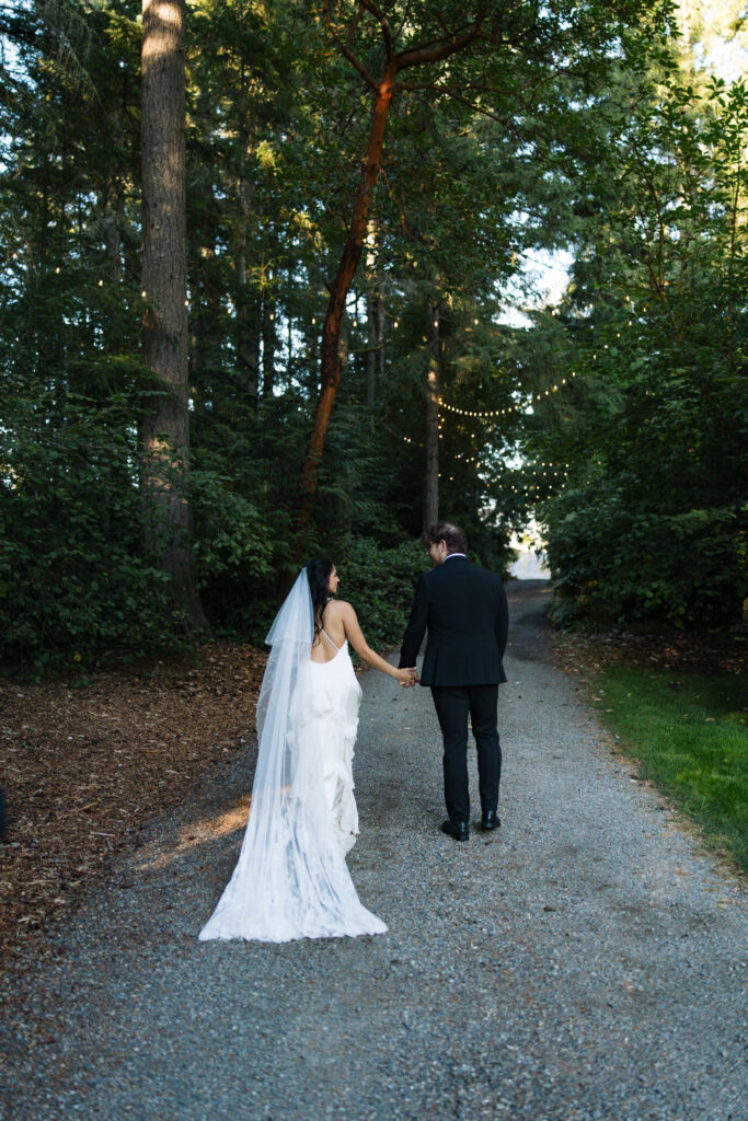 Couple walking hand in hand along the forest path at Foxglove Lodge Vashon Island.
