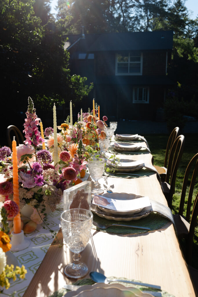 Whimsical reception table in golden light on the Arboretum Lawn at Foxglove Lodge Vashon.