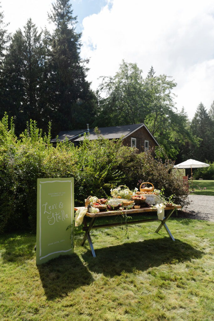 Welcome sign and grazing table for a Foxglove Lodge Vashon wedding reception.
