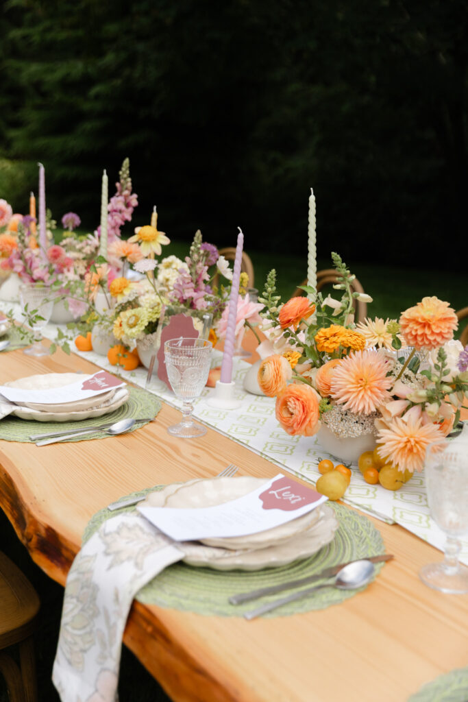 Whimsical reception table with colorful flowers, candles, and place settings at Foxglove Lodge Vashon.