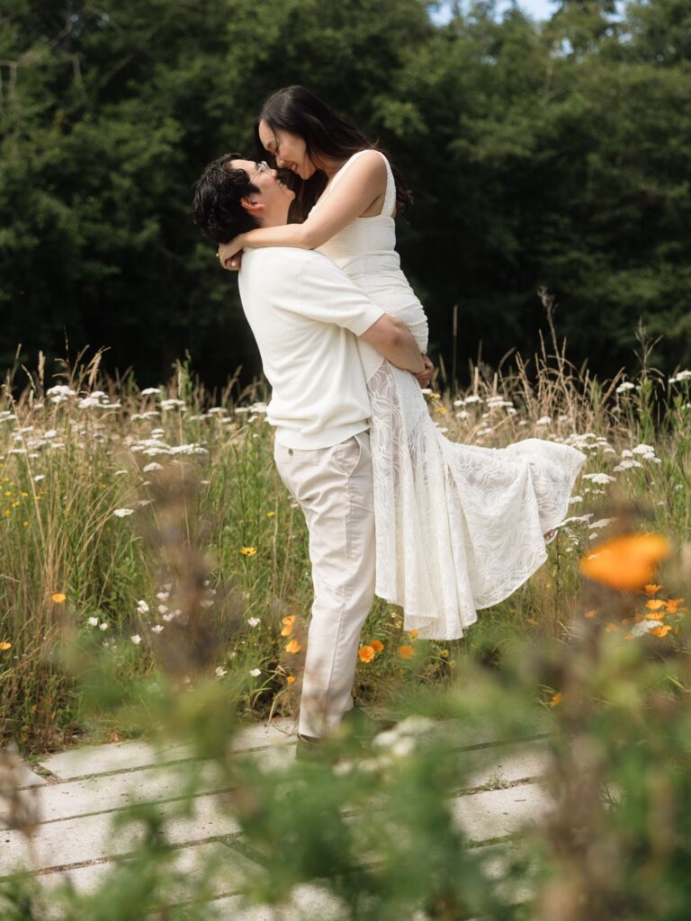 Couple kissing in a patch of wildflowers at Bloedel Reserve in WA.