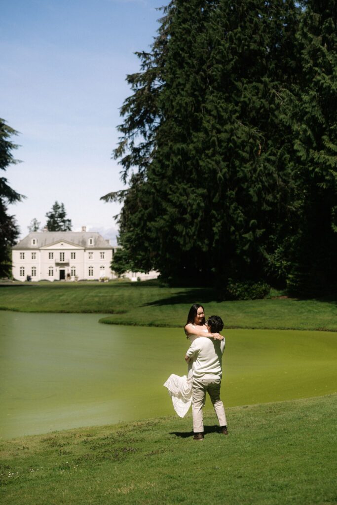 Man lifting up his fiancé during their Bloedel Reserve engagement photos in Washington.