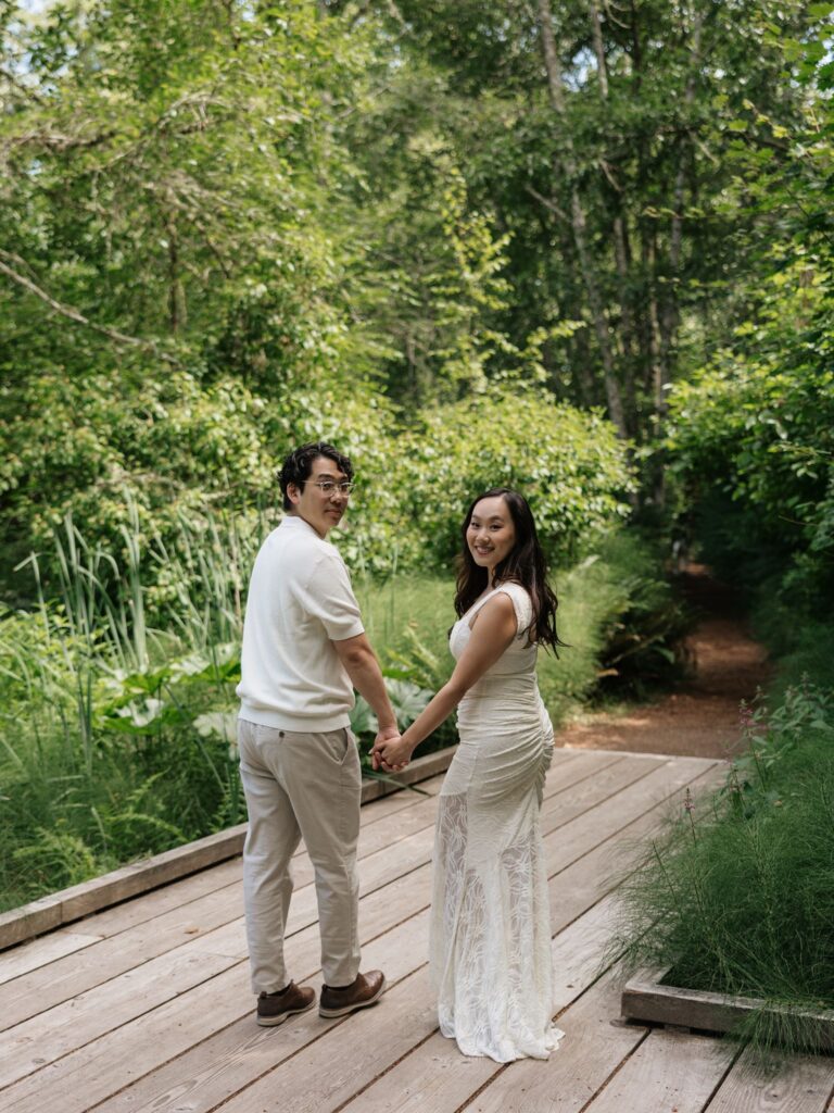 Couple walking along a dock for their outdoor engagement photos.