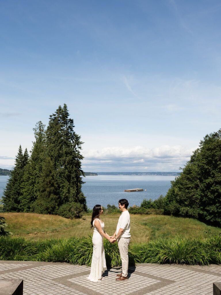 Couple holding hands near the water at Bloedel Reserve for their engagement photos.