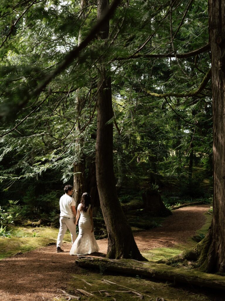 Couple walking a wooded pathway at Bloedel Reserve for their Washington engagement photos.