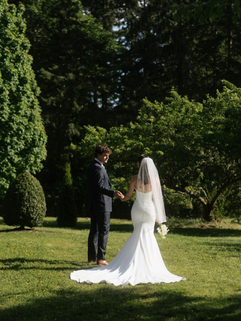 Bride and groom holding hands on an open lawn after their Froggsong Gardens wedding.