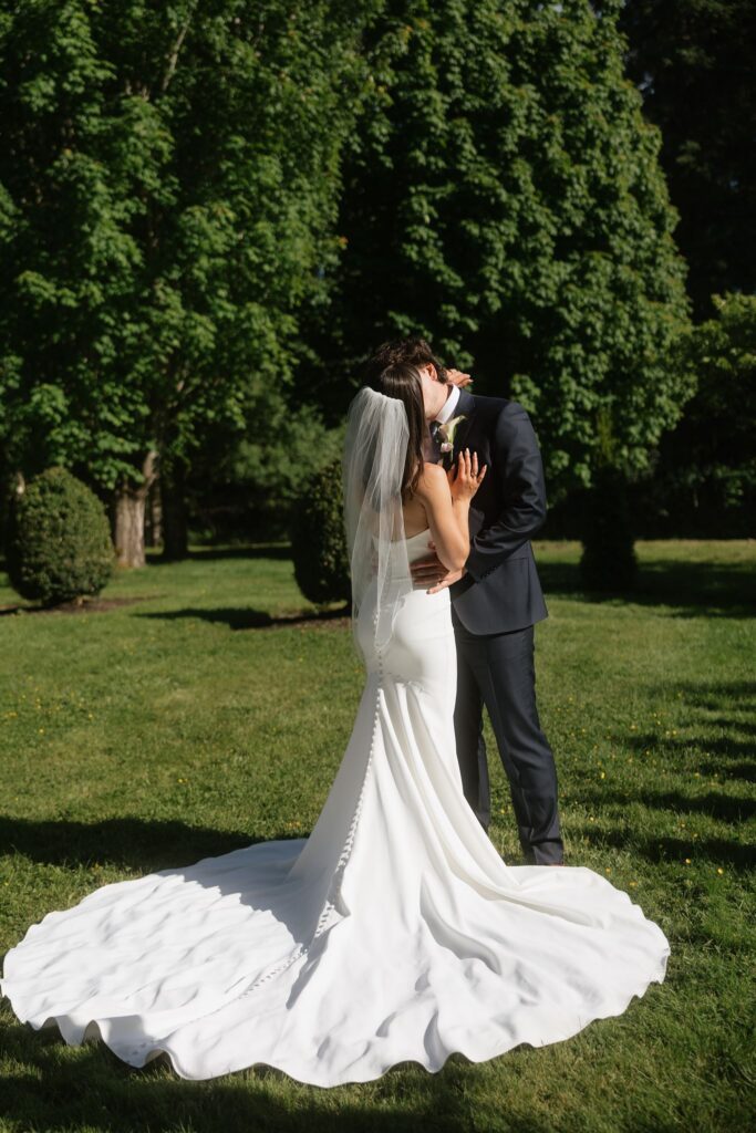 Bride and groom kissing during their Froggsong Gardens wedding photos.