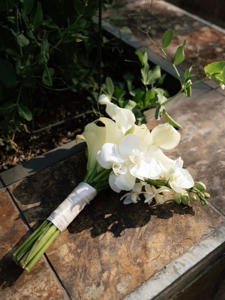 Brides calla lilly bouquet resting on a surface.