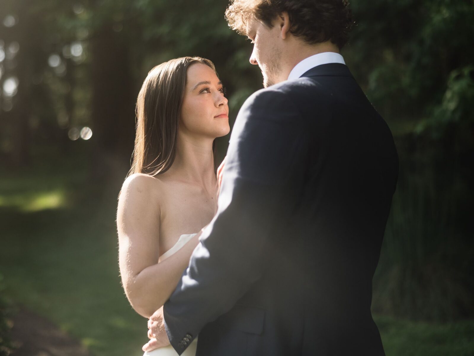 Bride looking up at the groom during sunlit wedding portraits on Vashon Island.